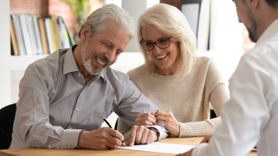 Man and woman signing paperwork to cancel their Denver vacation ownership contract.