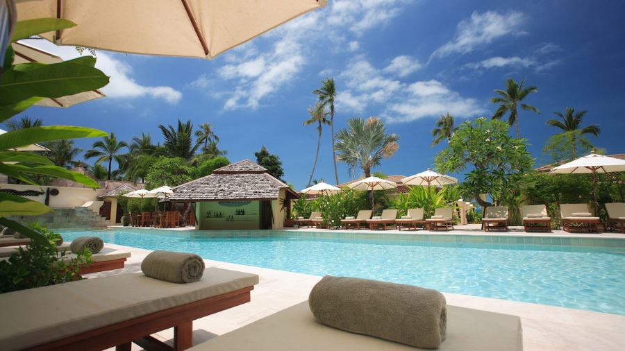 View of resort with pool and lounge chairs, evaluated by our timeshare cancellation company near New Orleans, Louisiana.